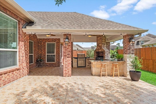 18135 Berry Garden Ln, Spring, TX 77379 - fenced backyard with ceiling fan, a patio area, a fireplace, a bar, and area for grilling