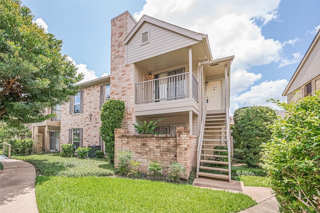 3100 Jeanetta St Unit 1104, Houston, TX 77063 - view of front of home with stairway, a front yard, a chimney, brick siding, and a balcony