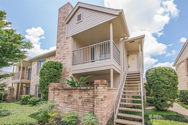 3100 Jeanetta St Unit 1104, Houston, TX 77063 - view of side of property with stairway, a balcony, brick siding, and a chimney