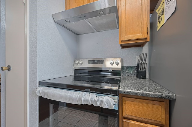 3100 Jeanetta St Unit 1104, Houston, TX 77063 - kitchen with stainless steel appliances, exhaust hood, tile patterned floors, and dark stone counters