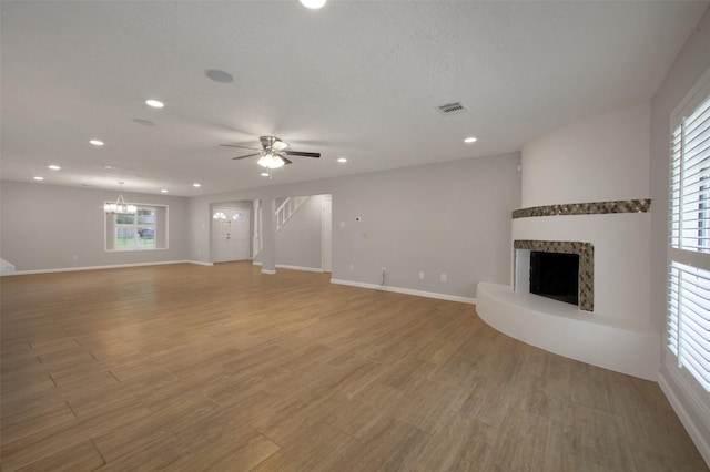 15815 Baytree Dr, Houston, TX 77070 - unfurnished living room featuring a fireplace with raised hearth, plenty of natural light, light wood-style floors, recessed lighting, and ceiling fan
