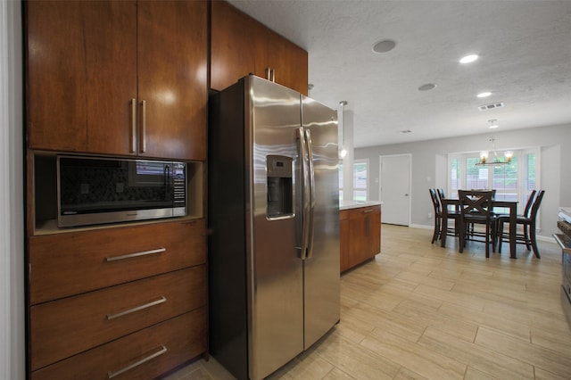 15815 Baytree Dr, Houston, TX 77070 - kitchen with stainless steel appliances, recessed lighting, light countertops, hanging light fixtures, and a chandelier