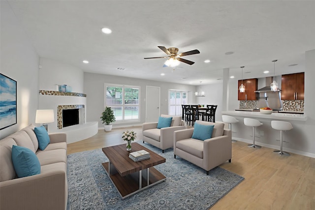 15815 Baytree Dr, Houston, TX 77070 - living area featuring light wood-type flooring, a ceiling fan, recessed lighting, and a fireplace with raised hearth