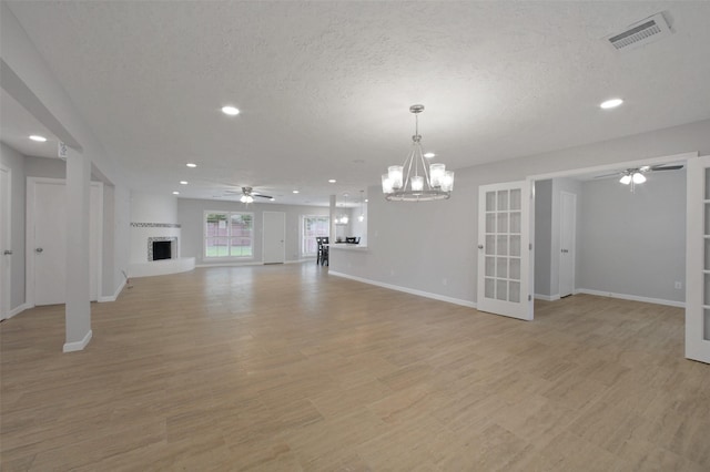 15815 Baytree Dr, Houston, TX 77070 - unfurnished living room featuring ceiling fan, recessed lighting, a fireplace with raised hearth, light wood-style floors, and a textured ceiling