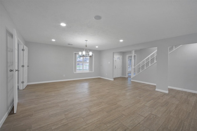 15815 Baytree Dr, Houston, TX 77070 - unfurnished living room with a chandelier, recessed lighting, stairway, and light wood-style floors