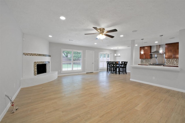 15815 Baytree Dr, Houston, TX 77070 - living room with a ceiling fan, recessed lighting, light wood-type flooring, a chandelier, and a fireplace with raised hearth