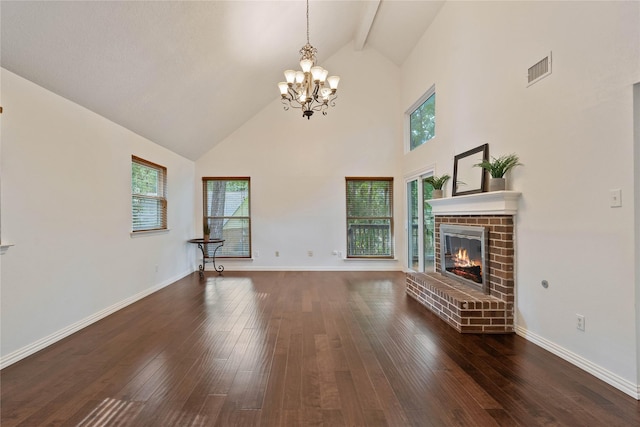 6 Sylvan Forest Dr, The Woodlands, TX 77381 - unfurnished living room with high vaulted ceiling, a chandelier, hardwood / wood-style flooring, beamed ceiling, and a brick fireplace