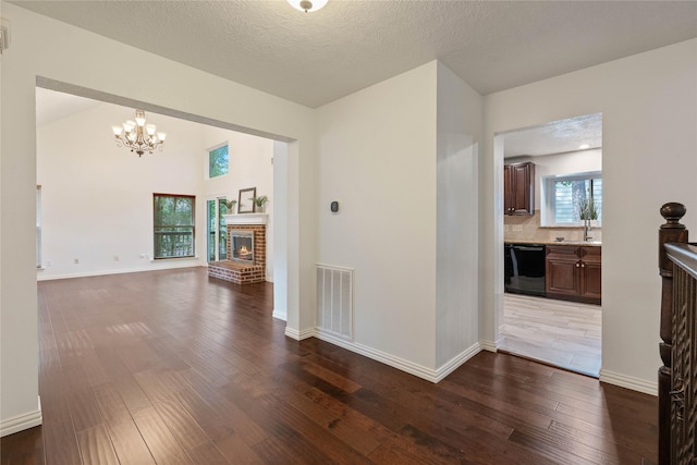 6 Sylvan Forest Dr, The Woodlands, TX 77381 - interior space featuring dark wood finished floors, a chandelier, and a brick fireplace
