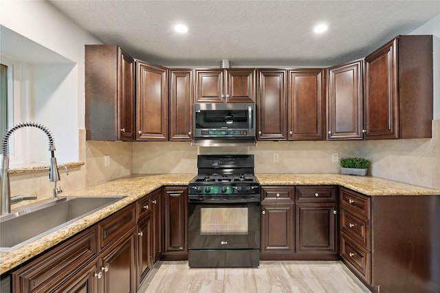 6 Sylvan Forest Dr, The Woodlands, TX 77381 - kitchen featuring stainless steel microwave, black range with gas stovetop, backsplash, light stone countertops, and recessed lighting