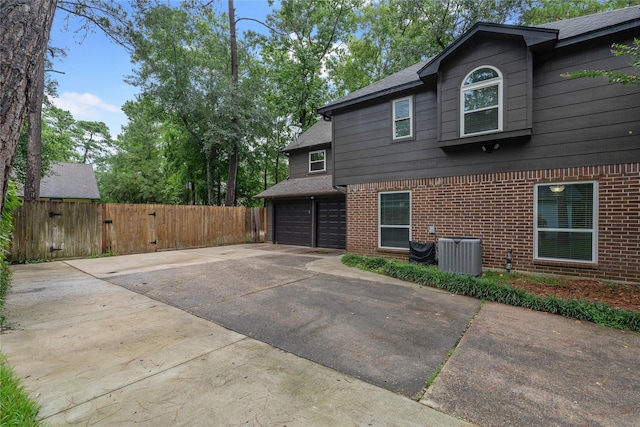 6 Sylvan Forest Dr, The Woodlands, TX 77381 - view of home's exterior featuring brick siding, driveway, a garage, and a gate