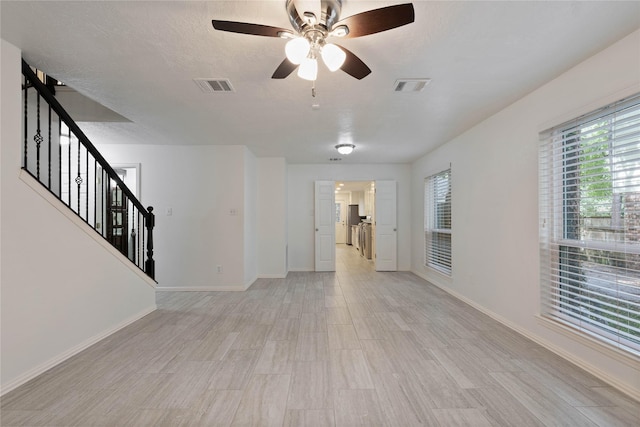6 Sylvan Forest Dr, The Woodlands, TX 77381 - unfurnished living room featuring healthy amount of natural light, ceiling fan, and stairway