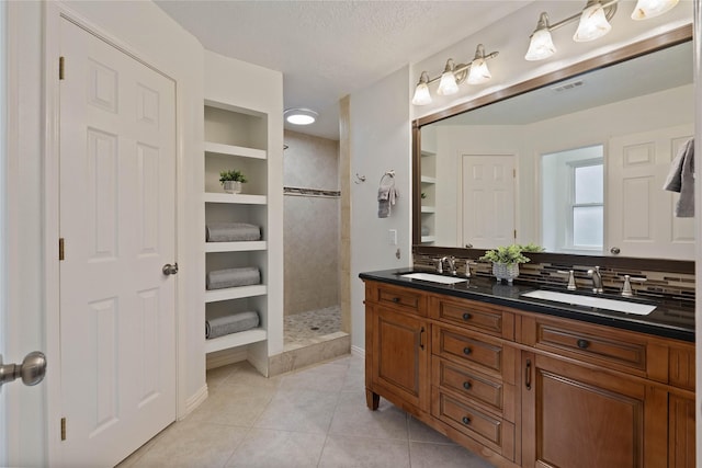 6 Sylvan Forest Dr, The Woodlands, TX 77381 - full bathroom featuring double vanity, walk in shower, tile patterned flooring, and a textured ceiling