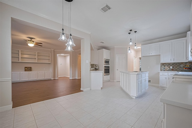 1902 Rosebay Ct, Sugar Land, TX 77479 - kitchen with light tile patterned floors, open floor plan, decorative backsplash, white cabinetry, and crown molding