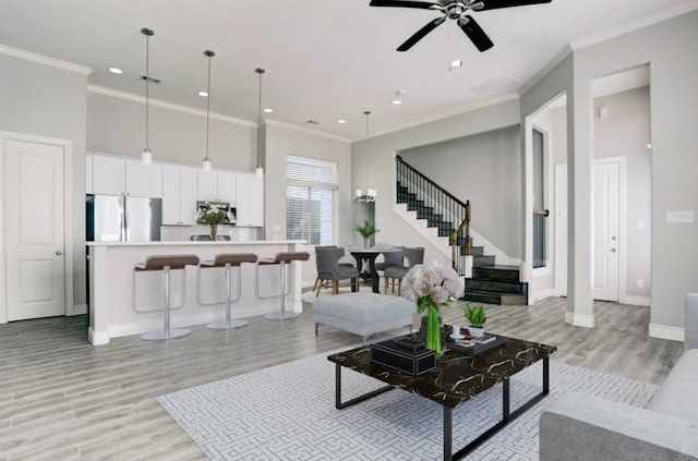 8907 Spring Knoll Forest Dr, Houston, TX 77080 - living area featuring crown molding, stairs, light wood-type flooring, ceiling fan, and recessed lighting