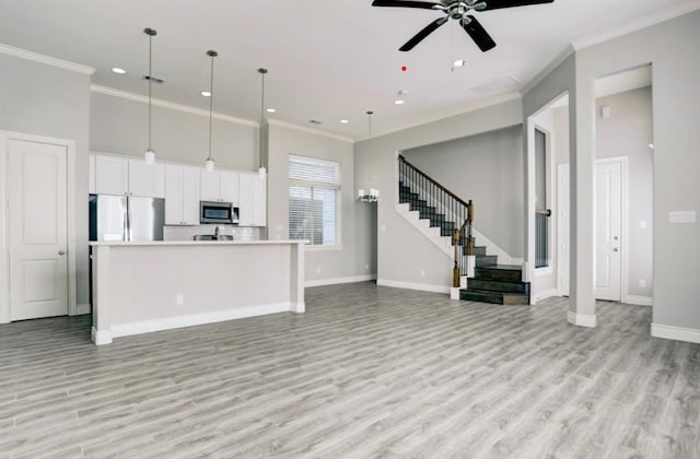8907 Spring Knoll Forest Dr, Houston, TX 77080 - kitchen with stainless steel appliances, ornamental molding, open floor plan, ceiling fan, and light wood finished floors