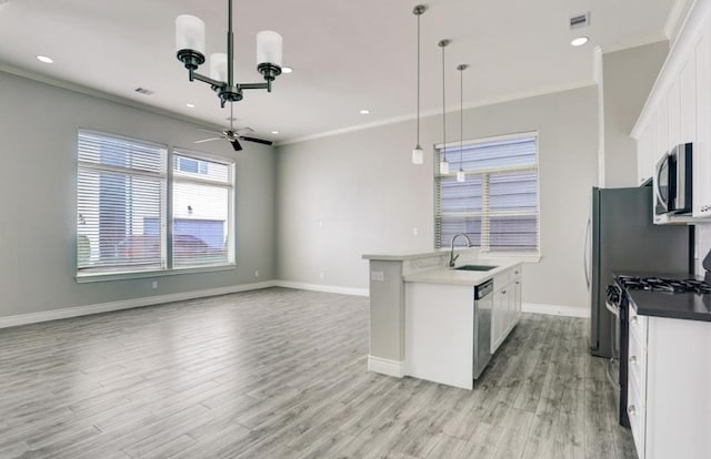 8907 Spring Knoll Forest Dr, Houston, TX 77080 - kitchen featuring ornamental molding, a chandelier, light wood finished floors, stainless steel appliances, and white cabinetry