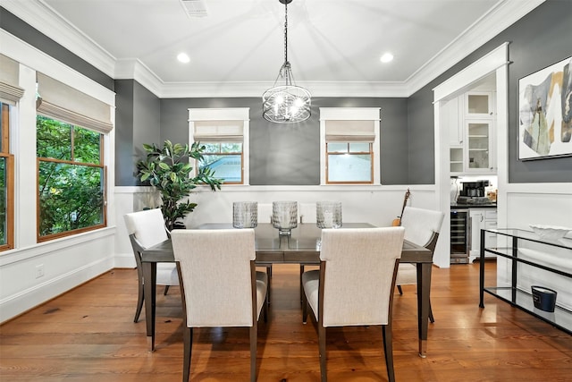 829 Ralfallen St, Houston, TX 77008 - dining area featuring beverage cooler, wainscoting, a chandelier, ornamental molding, and wood finished floors