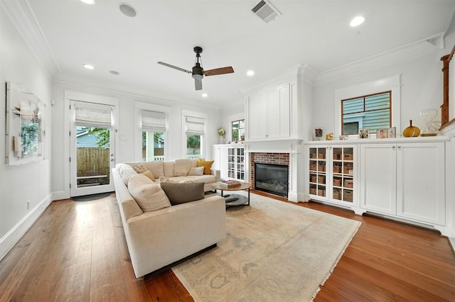 829 Ralfallen St, Houston, TX 77008 - living area featuring plenty of natural light, ceiling fan, a glass covered fireplace, ornamental molding, and wood finished floors
