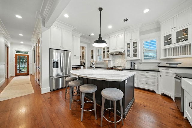 829 Ralfallen St, Houston, TX 77008 - kitchen featuring stainless steel appliances, a center island with sink, white cabinets, crown molding, and recessed lighting