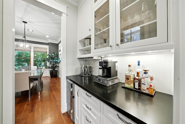 829 Ralfallen St, Houston, TX 77008 - indoor dry bar featuring ornamental molding, beverage cooler, a chandelier, dark wood-type flooring, and decorative light fixtures