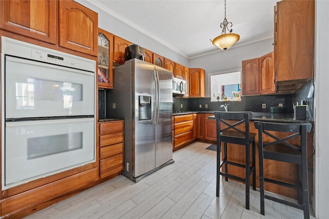 1805 19th St, Galveston, TX 77550 - kitchen featuring appliances with stainless steel finishes, dark countertops, brown cabinets, and crown molding