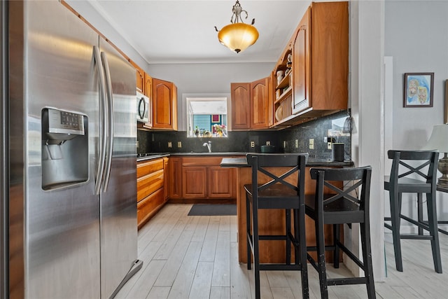 1805 19th St, Galveston, TX 77550 - kitchen with appliances with stainless steel finishes, brown cabinets, dark countertops, decorative backsplash, and crown molding