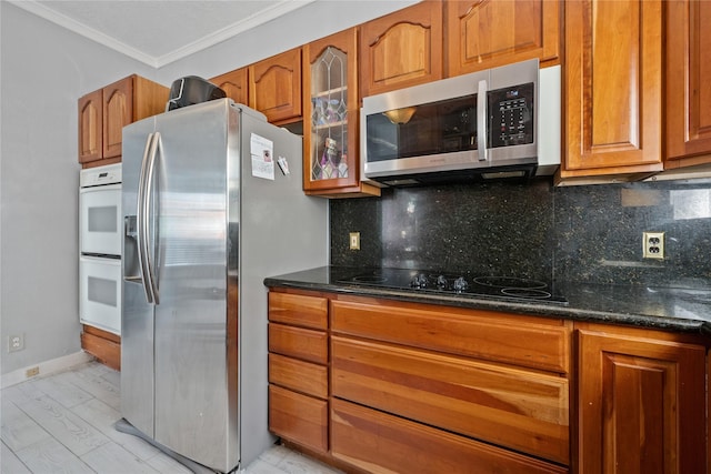1805 19th St, Galveston, TX 77550 - kitchen featuring stainless steel appliances, crown molding, brown cabinets, tasteful backsplash, and glass insert cabinets
