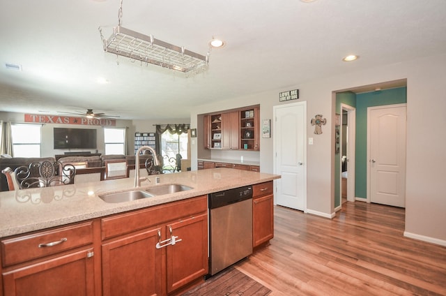 22218 Woodseem Ct, Katy, TX 77449 - kitchen with stainless steel dishwasher, light wood-style floors, recessed lighting, light stone countertops, and brown cabinets
