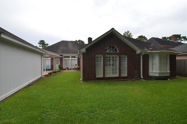 2014 Shadow Forest Dr, Katy, TX 77494 - back of house featuring brick siding, a chimney, and a yard