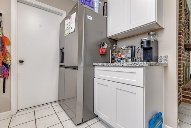 7307 Sunlight Ln, Houston, TX 77095 - kitchen featuring stainless steel fridge, light tile patterned floors, white cabinets, and light stone countertops