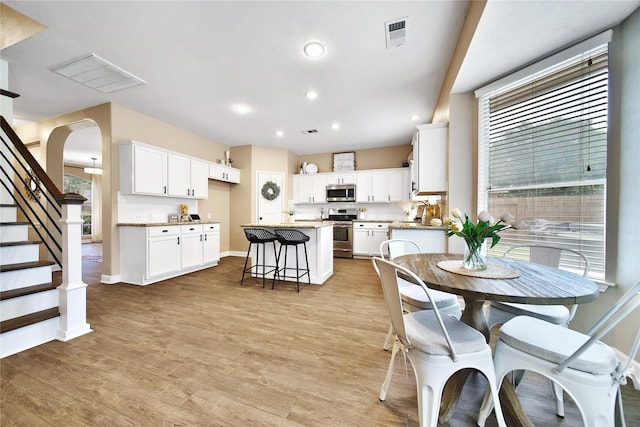 18219 Water Mill Dr, Cypress, TX 77429 - dining space featuring recessed lighting, light wood-style flooring, stairway, and arched walkways