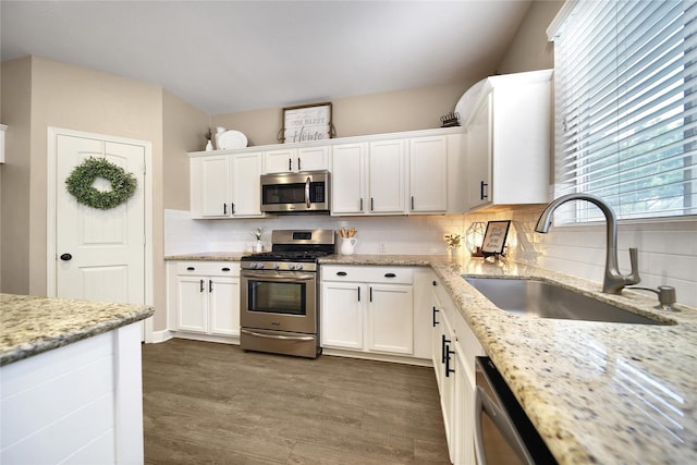 18219 Water Mill Dr, Cypress, TX 77429 - kitchen featuring appliances with stainless steel finishes, white cabinets, tasteful backsplash, dark wood-style flooring, and light stone countertops