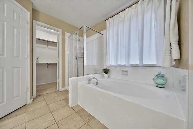 18219 Water Mill Dr, Cypress, TX 77429 - full bathroom featuring a shower stall, a bath, a spacious closet, and tile patterned flooring