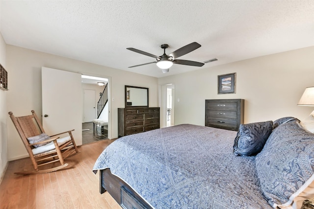 3510 Ledgestone Dr, Houston, TX 77059 - bedroom with light wood finished floors, a ceiling fan, and a textured ceiling