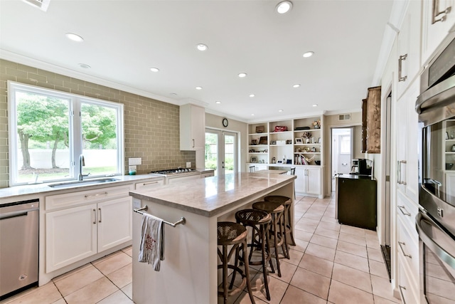 3510 Ledgestone Dr, Houston, TX 77059 - kitchen with crown molding, stainless steel appliances, a kitchen island, a breakfast bar, and white cabinets