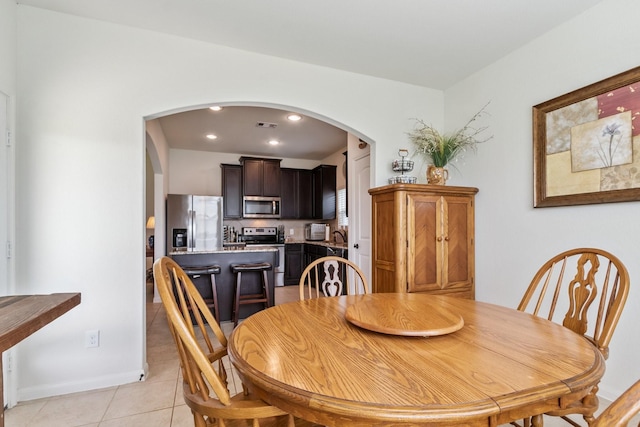 21015 Echo Manor Dr, Hockley, TX 77447 - dining space featuring arched walkways, light tile patterned flooring, and recessed lighting