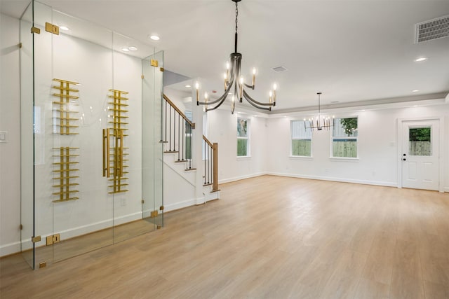 882 Prosper St, Houston, TX 77088 - unfurnished living room with a chandelier, light wood finished floors, stairway, and recessed lighting