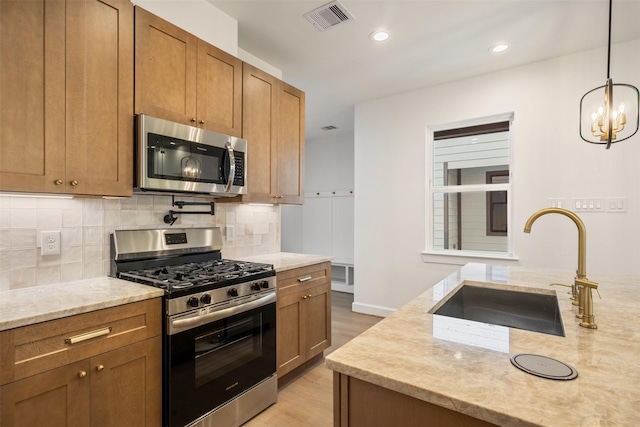 882 Prosper St, Houston, TX 77088 - kitchen featuring stainless steel appliances, tasteful backsplash, light wood-type flooring, light stone countertops, and brown cabinets