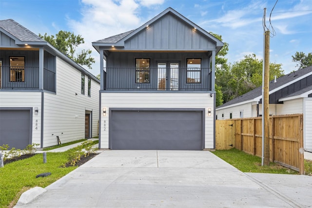 882 Prosper St, Houston, TX 77088 - view of front of home featuring board and batten siding, driveway, a garage, and a balcony