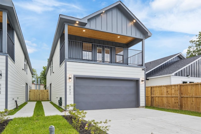882 Prosper St, Houston, TX 77088 - modern home with board and batten siding, a balcony, an attached garage, and concrete driveway