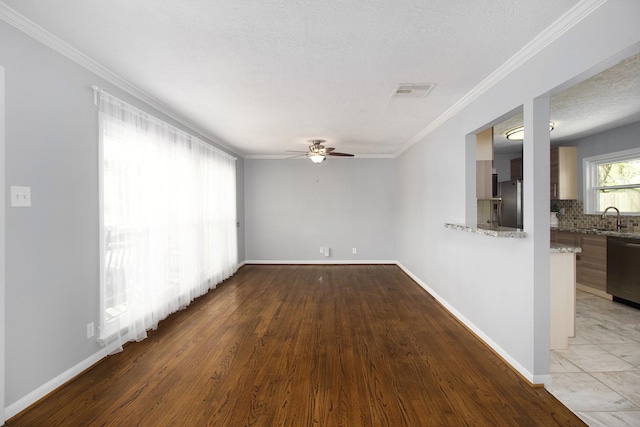 8106 Montridge Dr, Houston, TX 77055 - spare room featuring ceiling fan, crown molding, light wood-type flooring, and a textured ceiling