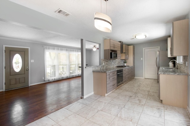 8106 Montridge Dr, Houston, TX 77055 - kitchen featuring stainless steel appliances, tasteful backsplash, a ceiling fan, a textured ceiling, and wall chimney range hood