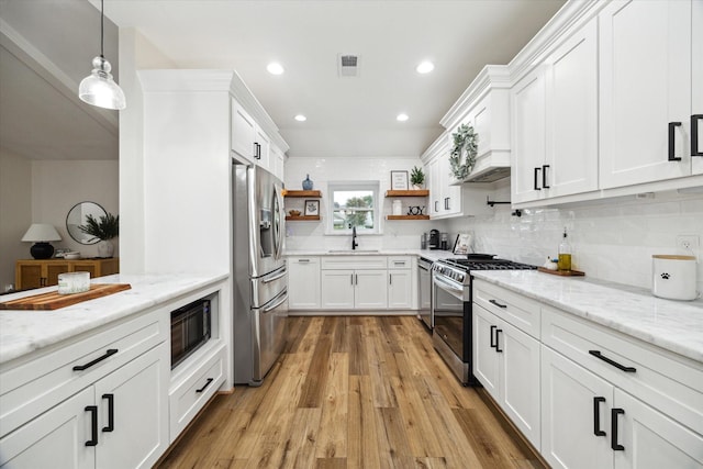 16217 Singapore Ln, Jersey Village, TX 77040 - kitchen featuring stainless steel appliances, open shelves, white cabinets, and recessed lighting