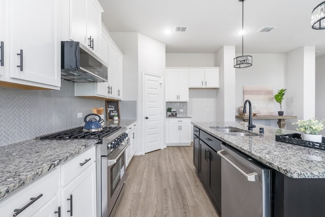 4118 Palmer Meadow Ct, Katy, TX 77494 - kitchen with appliances with stainless steel finishes, light wood finished floors, white cabinets, tasteful backsplash, and light stone countertops