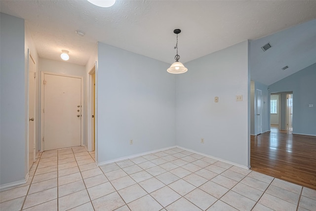 22522 Round Valley Dr, Katy, TX 77450 - empty room with light tile patterned flooring, vaulted ceiling, and a textured ceiling