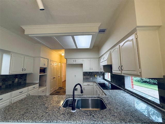 2147 Heather Green Dr, Houston, TX 77062 - kitchen with dark stone countertops, black electric stovetop, decorative backsplash, and crown molding