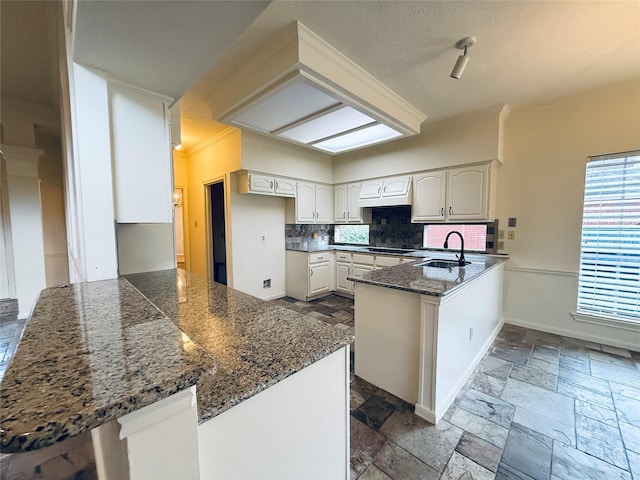 2147 Heather Green Dr, Houston, TX 77062 - kitchen featuring a peninsula, stone tile floors, tasteful backsplash, black electric cooktop, and custom range hood