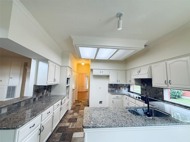 2147 Heather Green Dr, Houston, TX 77062 - kitchen featuring a peninsula, dark stone countertops, backsplash, and crown molding