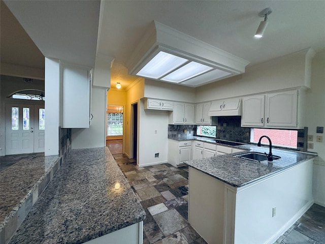 2147 Heather Green Dr, Houston, TX 77062 - kitchen featuring a peninsula, decorative backsplash, white cabinets, dark stone counters, and ornamental molding