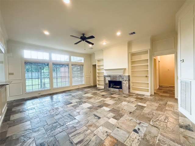 2147 Heather Green Dr, Houston, TX 77062 - unfurnished living room featuring built in shelves, a ceiling fan, recessed lighting, a high end fireplace, and stone tile flooring